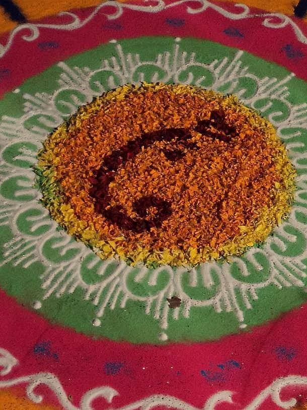Star-shaped floral rangoli, orange pink green