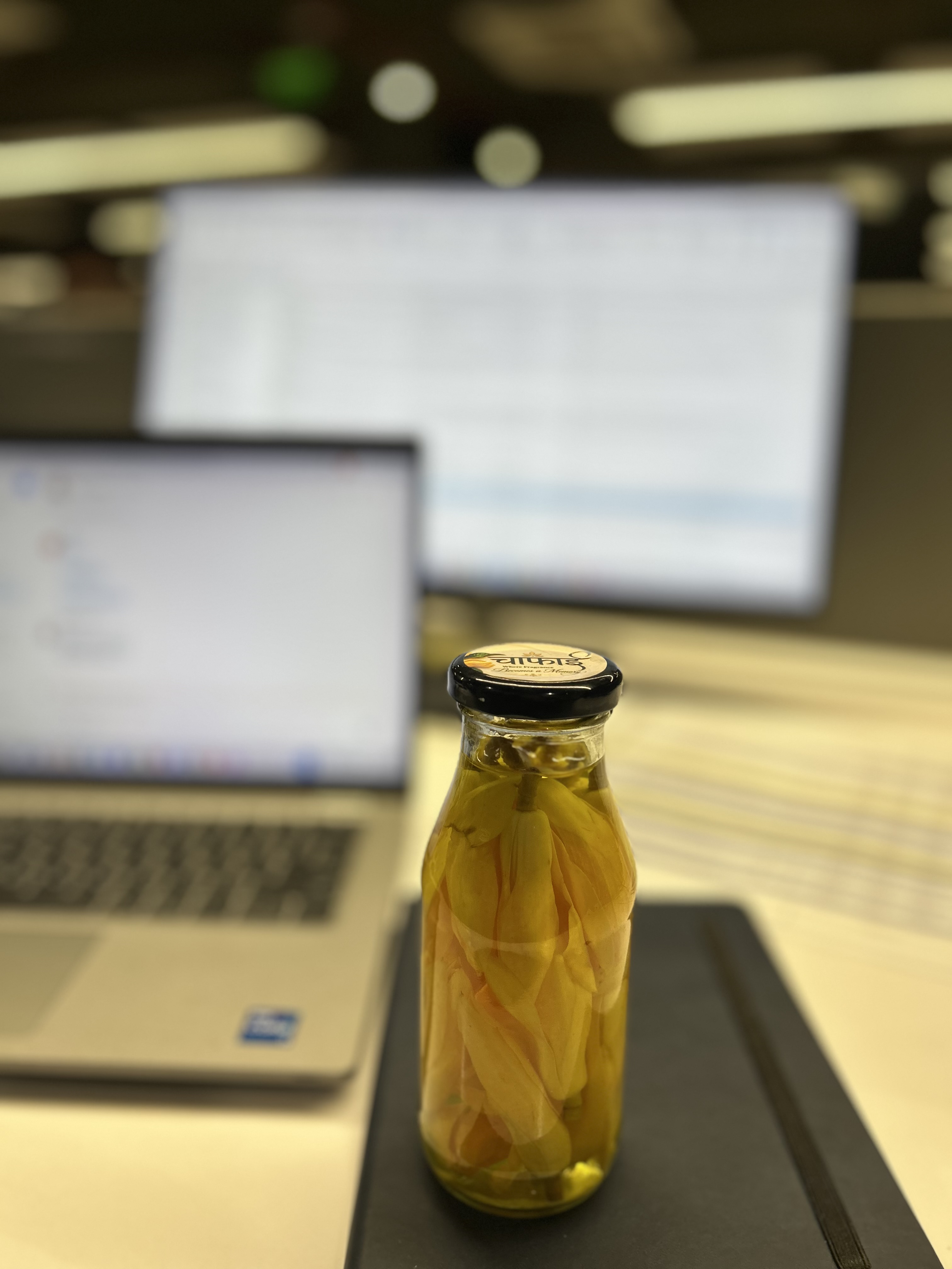 A bottle of Chafai kept beside a laptop on a desk
